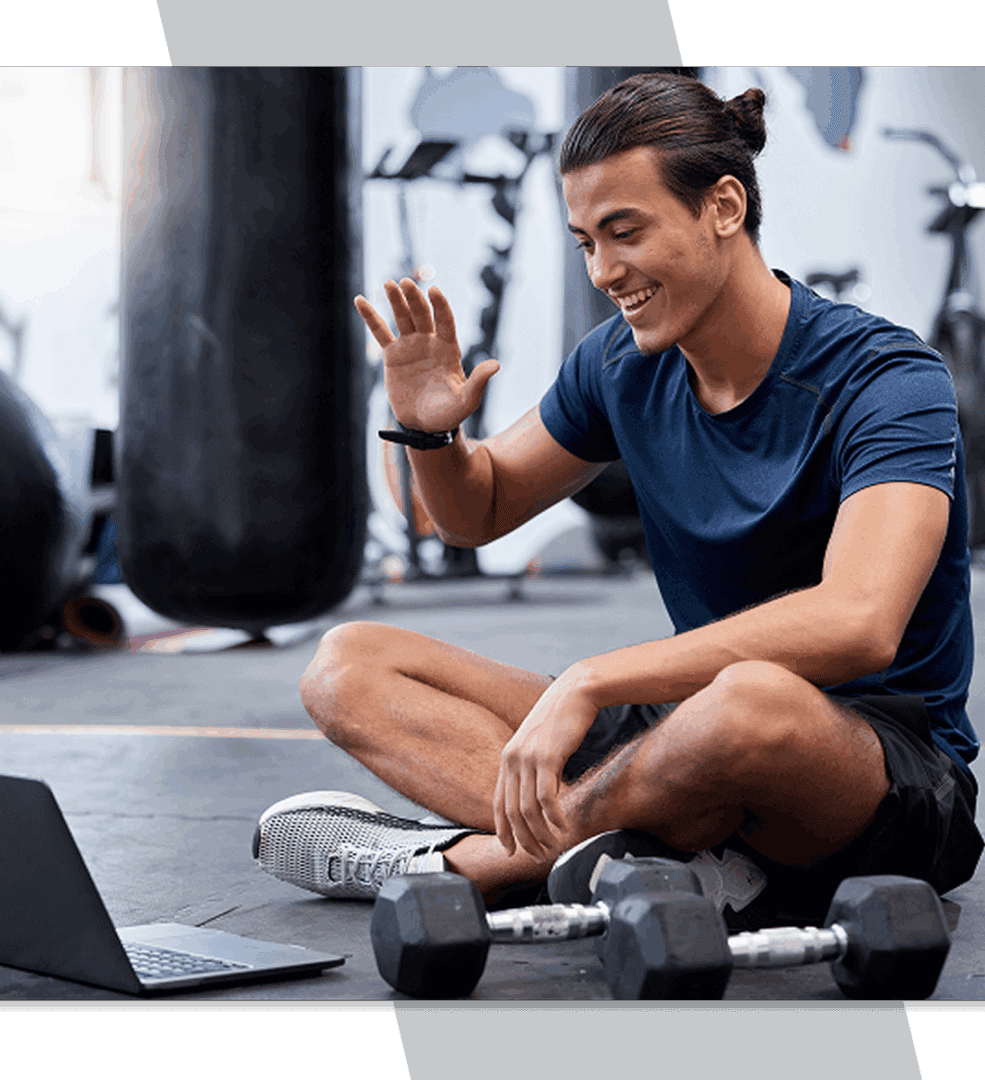 Man exercising with laptop in gym