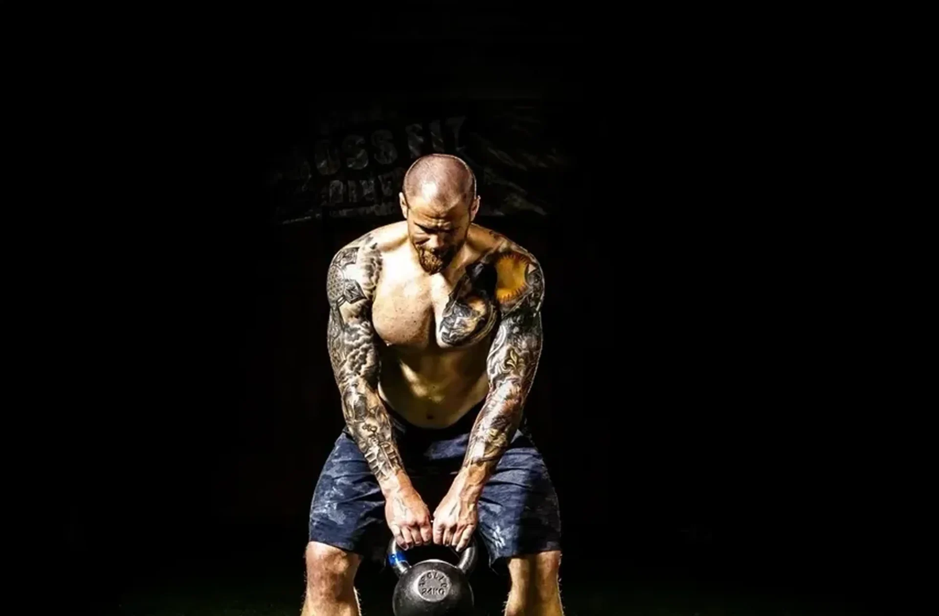 Man lifting kettlebell in dark gym