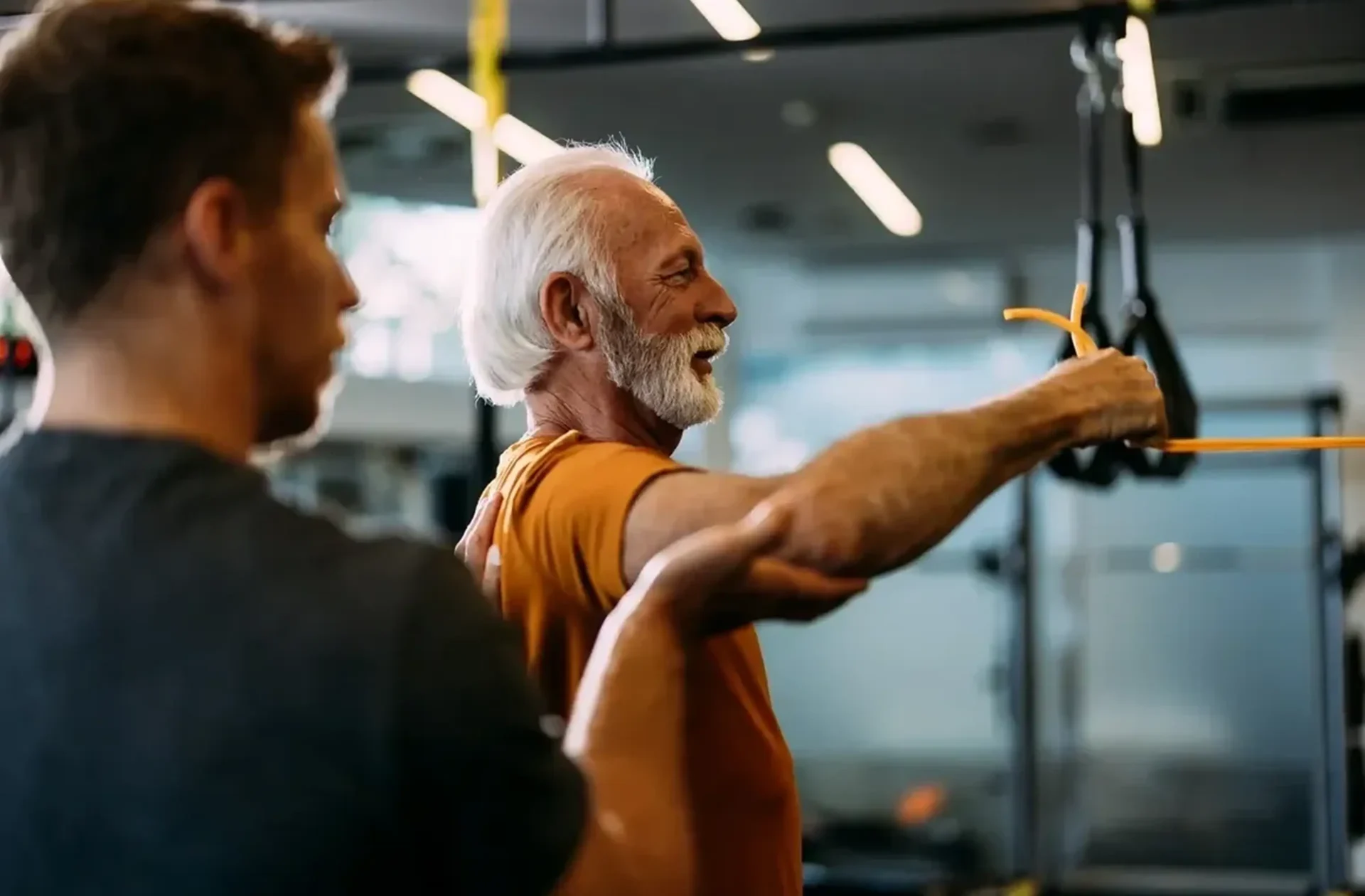 Man exercising with trainer in gym