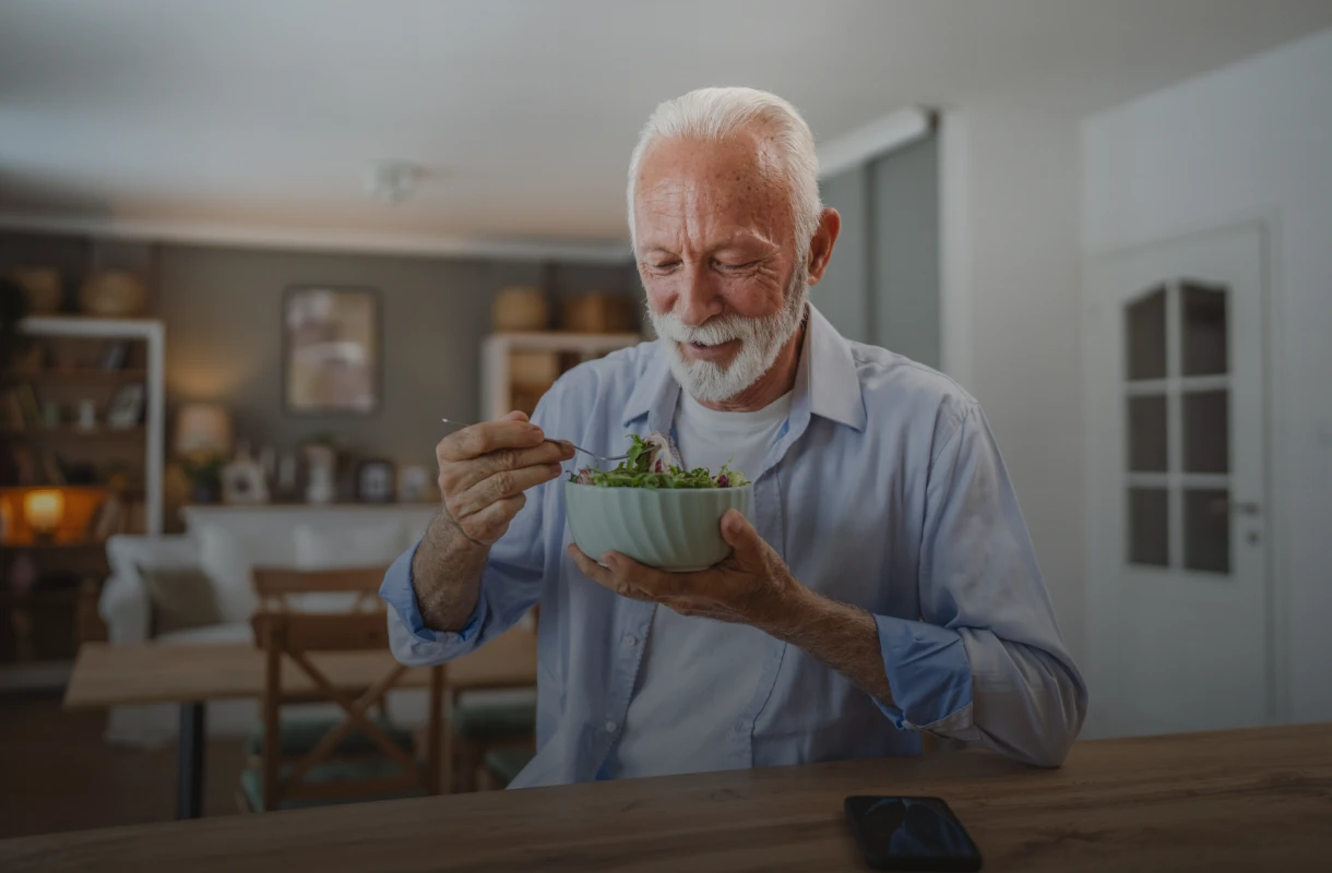 Senior eating healthy in living room
